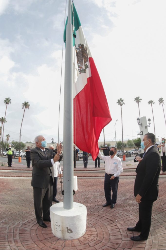 Al lado del contralor municipal, José Ángel Canales, iza la enseña nacional, en la Plaza Cívica Municipal